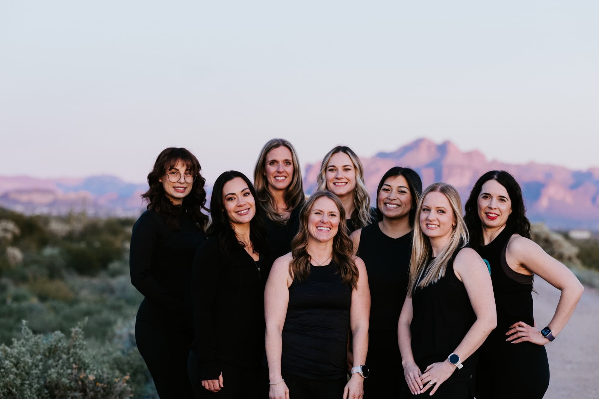 The AMP Fitness coaching team of certified coaches together at sunset in front of the Superstition Mountains near Mesa, AZ.